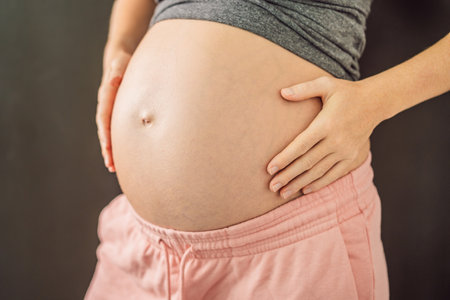 Cropped view of attractive pregnant woman touching large stomach parenthood preparationの写真素材
