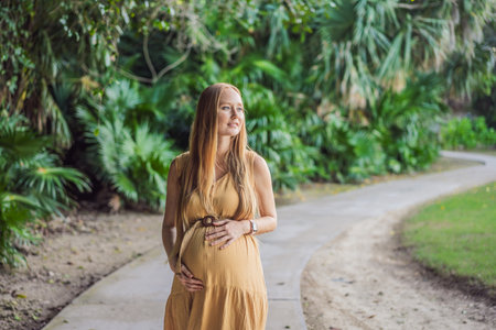 happy pregnant woman walking in the park