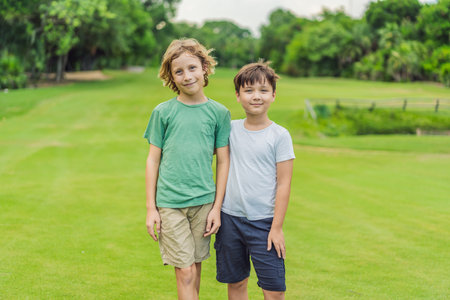 Two young boys share laughter and adventures in the sunlit park, cherishing the bonds of friendship and carefree momentsの写真素材
