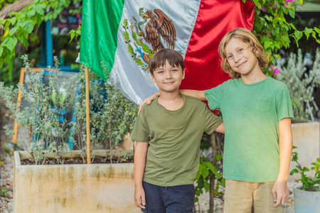 Immigrant boys in Mexico in front of the Mexican flag. New Mexicansの写真素材
