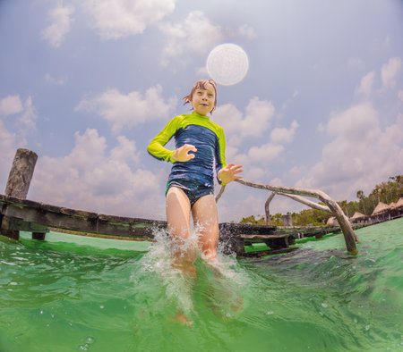 Joyful boy jumps into a turquoise lake in Mexicoの写真素材