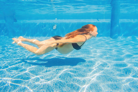 Pregnant serenity submerged a woman gracefully dives into the pool, celebrating the beauty of pregnancy with aquatic eleganceの写真素材