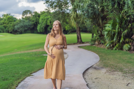 Tranquil scene as a pregnant woman enjoys peaceful moments in the park, embracing natures serenity and finding comfort during her pregnancyの写真素材