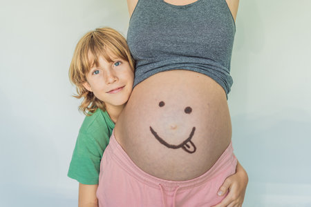 Adorable moment as a son adds a touch of joy to his mothers pregnancy, playfully drawing a funny...