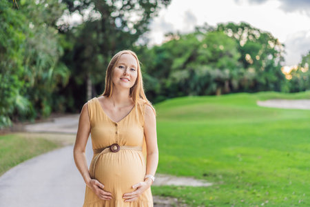 Tranquil scene as a pregnant woman enjoys peaceful moments in the park, embracing natures serenity and finding comfort during her pregnancyの写真素材