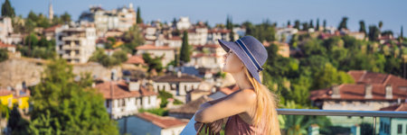 Woman tourist in Old town Kaleici in Antalya. Turkiye. Panoramic view of Antalya Old Town port, Taurus mountains and Mediterrranean Sea, Turkey BANNER, LONG FORMATの写真素材