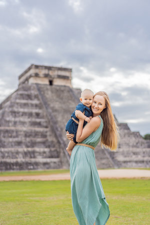 Beautiful tourist woman and her son observing the old pyramid and temple of the Mayan architecture...