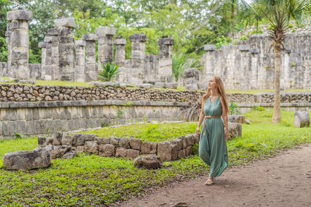 Beautiful woman observing the old pyramid and temple of the Mayan architecture known as Chichen...