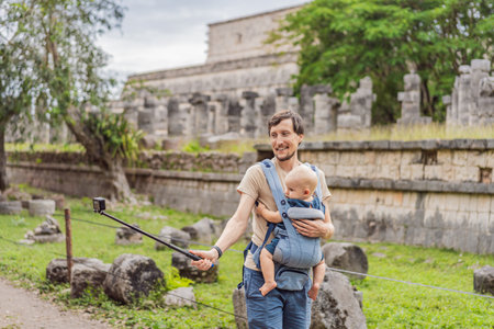 Father and son tourists observing the old pyramid and temple of the castle of the Mayan architecture known as Chichen Itza these are the ruins of this ancient pre-columbian civilization and part of humanityの写真素材