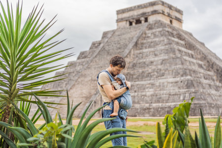 Father and son tourists observing the old pyramid and temple of the castle of the Mayan architecture...