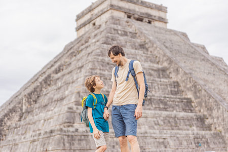 Father and son tourists observing the old pyramid and temple of the castle of the Mayan architecture...