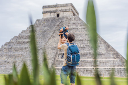 Father and son tourists observing the old pyramid and temple of the castle of the Mayan architecture...