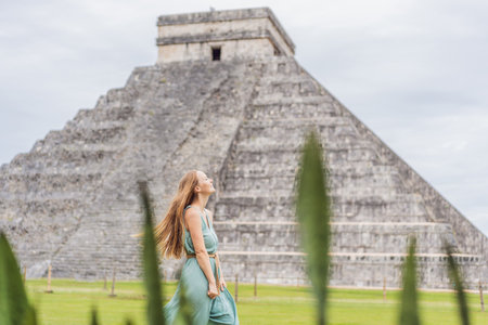 Beautiful tourist woman observing the old pyramid and temple of the castle of the Mayan architecture...