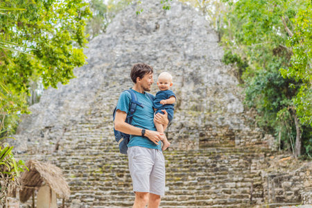 Dad and son tourists at Coba, Mexico. Ancient mayan city in Mexico. Coba is an archaeological area and a famous landmark of Yucatan Peninsula. Cloudy sky over a pyramid in Mexicoの写真素材