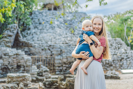 Mother and son tourists at Coba, Mexico. Ancient mayan city in Mexico. Coba is an archaeological area and a famous landmark of Yucatan Peninsula. Cloudy sky over a pyramid in Mexicoの写真素材