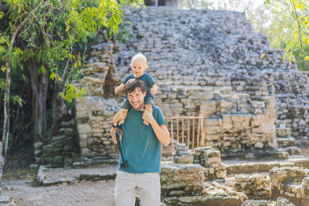 Dad and son tourists at Coba, Mexico. Ancient mayan city in Mexico. Coba is an archaeological area and a famous landmark of Yucatan Peninsula. Cloudy sky over a pyramid in Mexicoの写真素材
