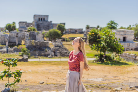 Woman tourist enjoying the view Pre-Columbian Mayan walled city of Tulum, Quintana Roo, Mexico, North America, Tulum, Mexico. El Castillo - castle the Mayan city of Tulum main templeの写真素材