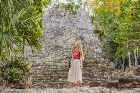 Woman tourist at Coba, Mexico. Ancient mayan city in Mexico. Coba is an archaeological area and a famous landmark of Yucatan Peninsula. Cloudy sky over a pyramid in Mexicoの写真素材