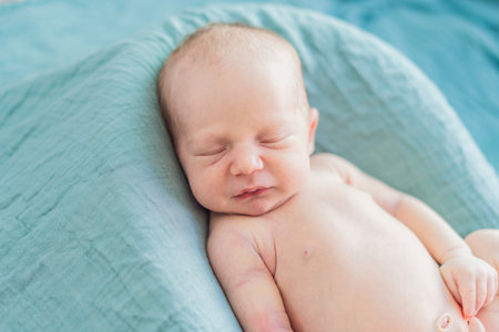 The baby is sleeping peacefully in his cozy nest. Newborn photo session captures the serene innocence and warmth of early momentsの写真素材