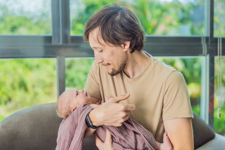Dad and newborn at home. This tender moment captures the bond between father and child in a loving and comfortable family environment highlighting the joys of parenthood and the warmth of homeの写真素材