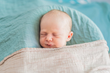 The baby is sleeping peacefully in his cozy nest. Newborn photo session captures the serene innocence and warmth of early momentsの写真素材