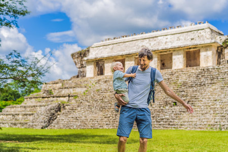 Father with his toddler son exploring the ancient pyramids of Palenque, Mexico, surrounded by dense jungle. Cultural heritage and adventure travel conceptの写真素材