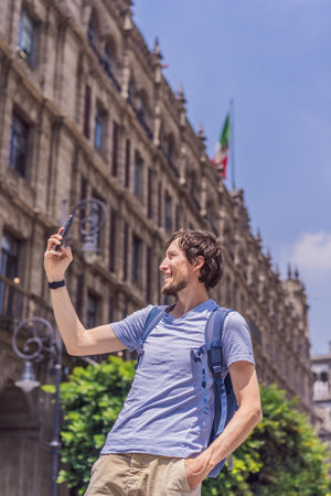 Male tourist in the central square of Mexico City, Zocalo. Cultural exploration, travel, and historic architecture conceptの写真素材