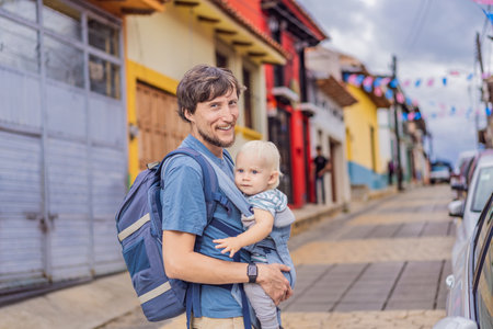 Father and his son tourists walk through the colonial streets San Cristobal de las Casas, Mexico. Cultural exploration, architecture, and travel experience conceptの写真素材