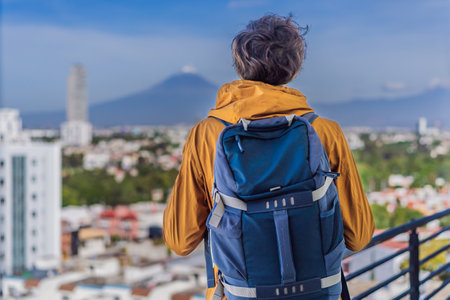 Male tourist in front of Popocatepetl Volcano, Mexico. Adventure, natural exploration, and travel experience conceptの写真素材