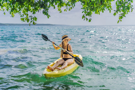 Woman kayaking on Bacalar Lake in Mexico. Adventure tourism in Quintana Roo, outdoor exploration, and water activities conceptの写真素材