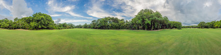 Scenic panorama of a tropical golf course surrounded by lush jungle. Serene landscape ideal for...