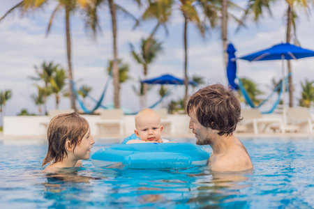 A father enjoys swimming in a pool with his son and infant, who is safely placed in an inflatable...