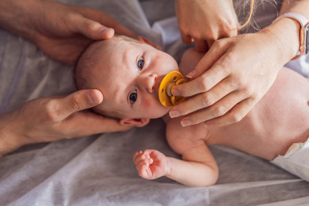 A newborn baby receives gentle osteopathic care, lying calmly while the specialist carefully examines and adjusts the infant. A moment of professional pediatric care, early development, and holistic well-being, symbolizing health and nurturing touchの写真素材