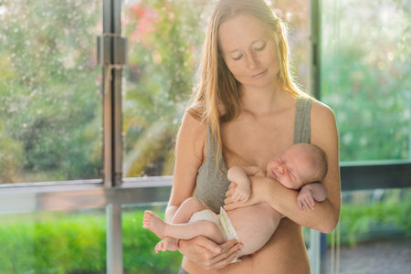 A mother lovingly embraces her newborn baby, holding them close to her chest. A tender moment of...