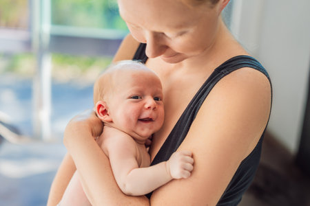 A mother lovingly embraces her newborn baby, holding them close to her chest. A tender moment of...