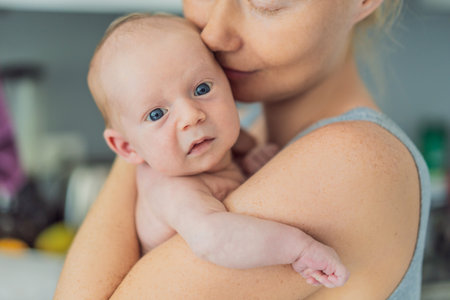 A mother lovingly embraces her newborn baby, holding them close to her chest. A tender moment of...