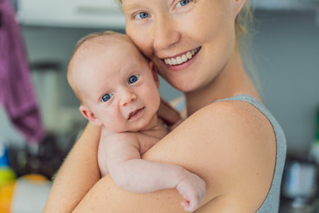 A mother lovingly embraces her newborn baby, holding them close to her chest. A tender moment of...