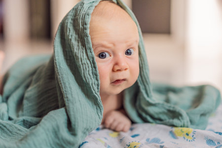 One-month-old baby lying on tummy and curiously observing surroundings. Infant tummy time for neck...