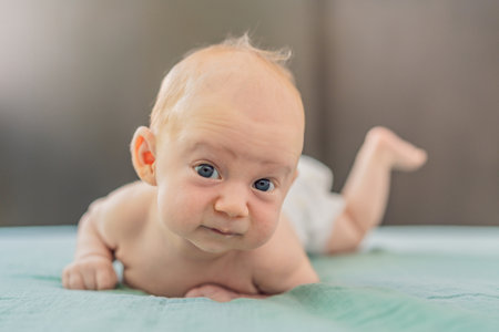 One-month-old baby lying on tummy and curiously observing surroundings. Infant tummy time for neck...