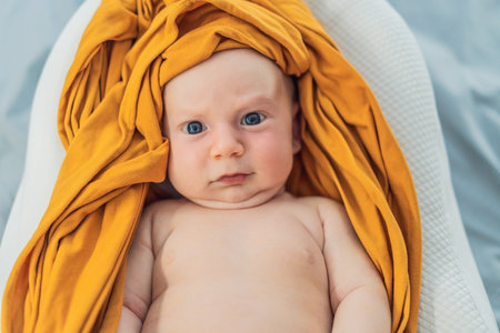 Newborn baby comfortably resting in a cozy baby nest. Safe and peaceful sleep concept for infants