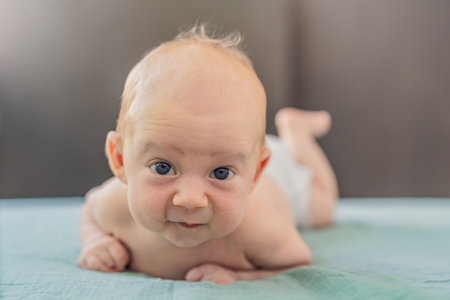 One-month-old baby lying on tummy and curiously observing surroundings. Infant tummy time for neck...