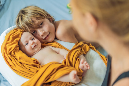 Older brother hugging his newborn sibling. Heartwarming family moment, love, and bonding between...