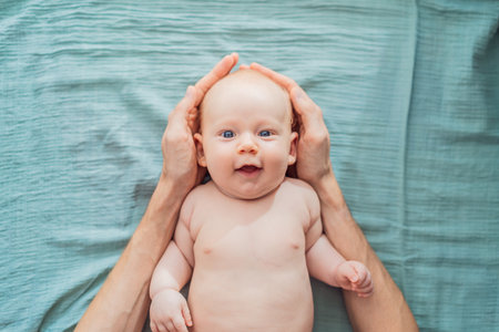 Father hands form a protective roof above baby head. Concept of safety, love, family protection, and emotional security in early childhoodの写真素材
