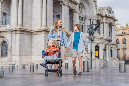 Mother tourist with her two sons in front of Palacio de Bellas Artes in Mexico City, enjoying family...