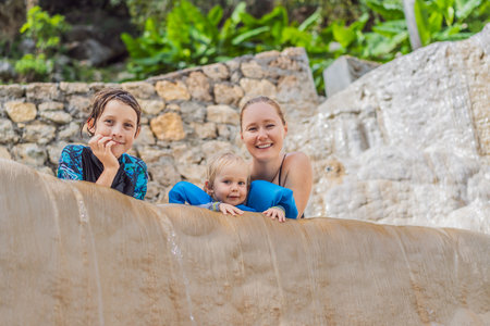 Mother with her toddler and teenage son bathing in the hot springs of Grutas Tolantongo, Mexico,...