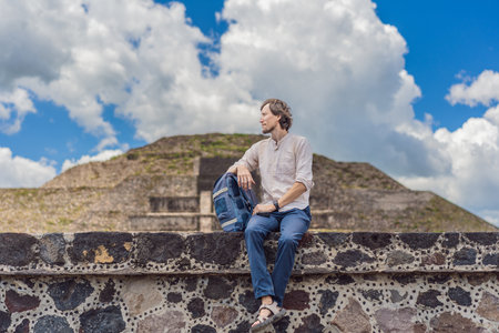 Male tourist posing in front of the pyramids of Teotihuacan in Mexico, enjoying sightseeing,...