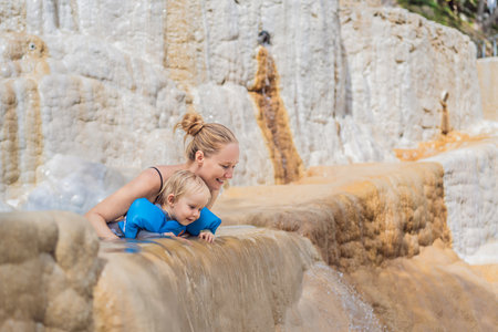 Mother and her toddler bathing in the hot springs of Grutas Tolantongo, Mexico, enjoying family bonding, wellness, and outdoor adventure conceptの写真素材