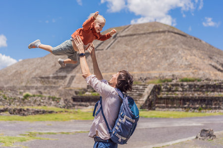 Father with his little toddler son as tourists in front of the pyramids of Teotihuacan in Mexico, enjoying sightseeing, family bonding, and cultural heritageの写真素材