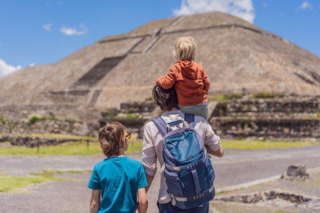 Father with his two sons as tourists in front of the pyramids of Teotihuacan, Mexico, enjoying family travel, sightseeing, and cultural heritage togetherの写真素材