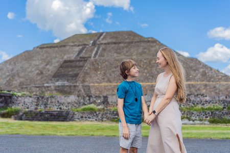 Mother and her son as tourists in front of Teotihuacan pyramids, Mexico, enjoying sightseeing,...